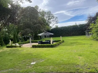 a garden with a table and an umbrella at Castle Gogar Cottage in Edinburgh