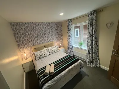 a bedroom with a bed with two shoes on it at Pheasant lodge - Balmaha 3 bed in Glasgow
