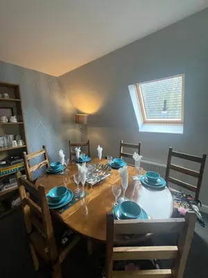 a dining room table with blue plates and glasses on it at Pheasant lodge - Balmaha 3 bed in Glasgow