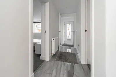 an empty hallway with white walls and wooden floors at Modern 3BHK near Edinburgh zoo in Edinburgh