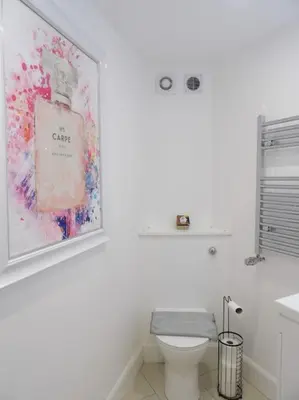 a bathroom with a toilet and a picture on the wall at Modern 3BHK near Edinburgh zoo in Edinburgh