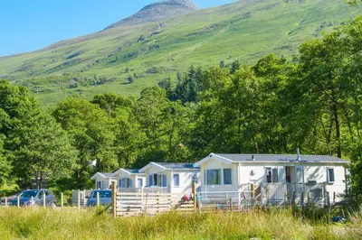 a row of mobile homes in front of a mountain at Heart of Glencoe Holidays in Glencoe