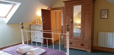 a bedroom with a bed and a dresser with towels at Heart of Glencoe Holidays in Glencoe