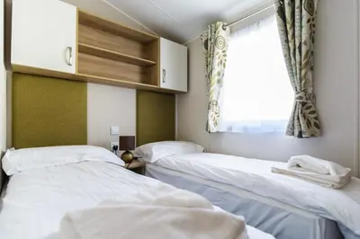 two beds in a room with a window at Heart of Glencoe Holidays in Glencoe