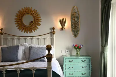 a bedroom with a bed and a mirror and a dresser at Kipney Hunting Lodge in Perth