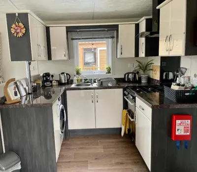 a kitchen with white cabinets and a sink at Honeycomb Lodge in Dollar