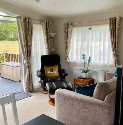 a living room with a couch and a chair at Honeycomb Lodge in Dollar