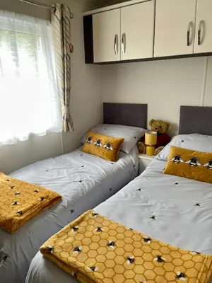two twin beds in a room with a window at Honeycomb Lodge in Dollar