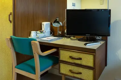a desk with a tv and a chair in a room at The Cedars Guest House in Dunoon