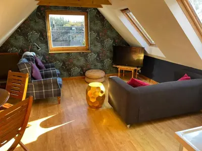 a living room with a couch and a television at Annexe Lodge cottage in Drymen in Drymen