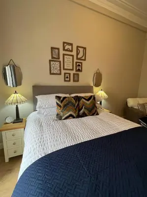 a bedroom with a blue and white bed and two lamps at Luxury Victorian spacious flat in Glasgow