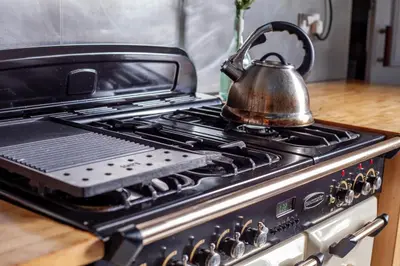 a tea kettle sitting on top of a stove at Stylish Victorian Apartment's close to the Botanical gardens, Free parking! in Edinburgh