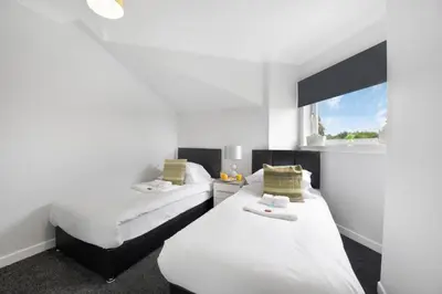 a room with two beds and a window at PREMIER - Clydesdale Apartment in Mossend