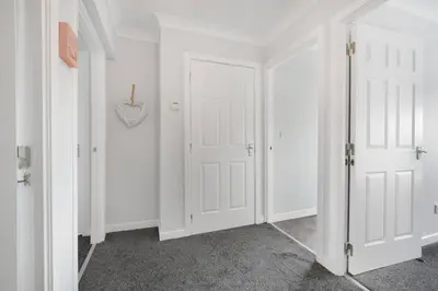 a hallway with white walls and white doors at PREMIER - Clydesdale Apartment in Mossend