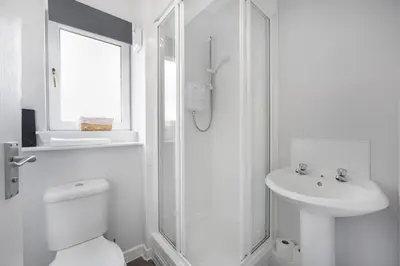 a white bathroom with a toilet and a sink at PREMIER - Clydesdale Apartment in Mossend