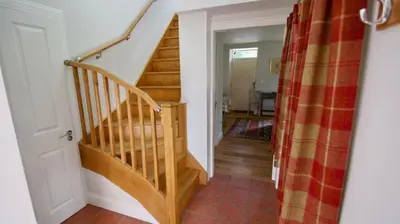 a hallway with a wooden staircase in a home at Edinample Lodge in Lochearnhead