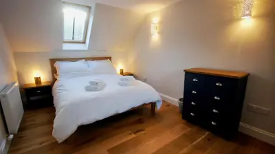 a bedroom with a bed with two towels on it at Edinample Lodge in Lochearnhead