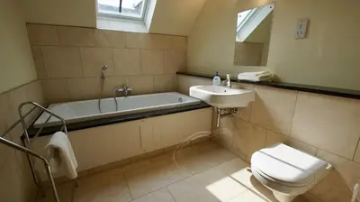 a bathroom with a tub and a toilet and a sink at Fire Station Cottage in Comrie