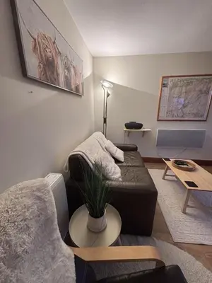 a living room with a couch and a table at Morenish Mews Killin Cottage in Morenish