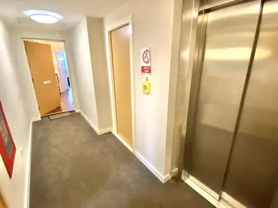 a hallway of an office building with a elevator at Penthouse Apartment in Stirling