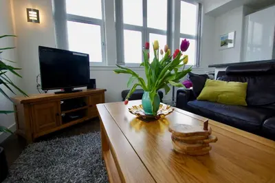 a living room with a coffee table and a tv at Penthouse Apartment in Stirling