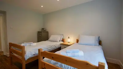 two twin beds in a room with a night stand at Ruchearn in Comrie