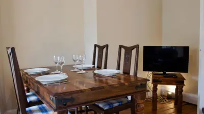 a wooden table with plates and wine glasses on it at Ruchearn in Comrie