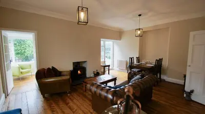 a living room with leather furniture and a fireplace at Ruchearn in Comrie