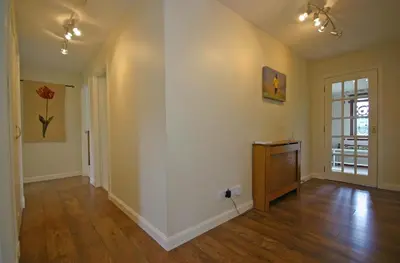 an empty living room with a wooden floor at Tomanour in Comrie