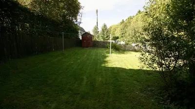 a yard with a fence and a net at Waterside in Braco