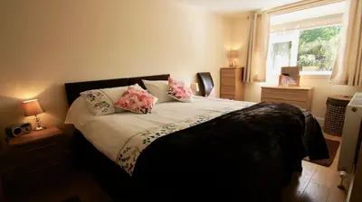 a bedroom with a bed with pillows and a window at Waterside in Braco