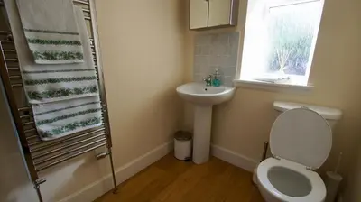 a bathroom with a toilet and a sink and a window at Waterside in Braco