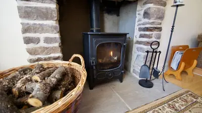 a fireplace with a wood stove in a room at Waterside in Braco