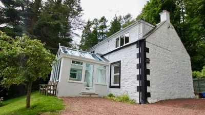 a small white cottage with a window on it at View Cottage in Lochearnhead