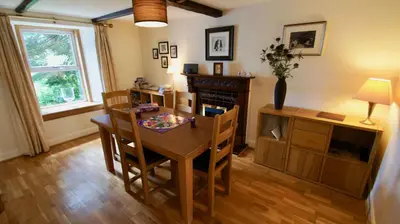 a dining room with a table and chairs and a desk at View Cottage in Lochearnhead
