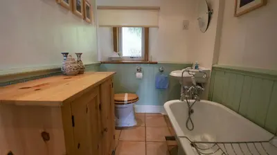 a bathroom with a tub and a sink and a toilet at View Cottage in Lochearnhead