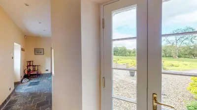 an open door to a room with a window at Airds of Kells House in Castle Douglas