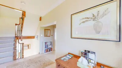 a living room with a table and a picture on the wall at Airds of Kells House in Castle Douglas