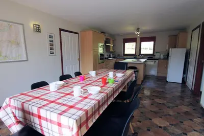 a kitchen with a table with a red and white checkered table cloth at Osprey View in Lochearnhead