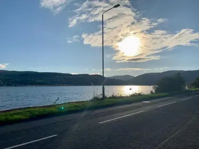 a street light on a road next to a body of water at 2 Bed Cottage Sleeps 2 - Parking Pet Friendly in Dunoon