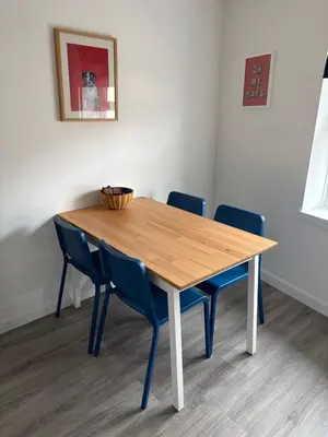 a wooden table with two blue chairs around it at 16 Macgregor court, Oban in Oban