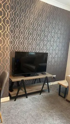 a television on a table in a room with a wall at Camisila in Campbeltown
