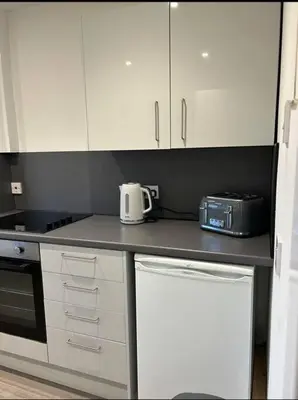a kitchen with white cabinets and a toaster on a counter at Camisila in Campbeltown
