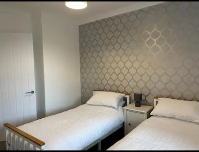 a bedroom with two beds and a wall at Camisila in Campbeltown