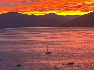 a group of boats in the water at sunset at Waverley Apartments, Crow's Nest in Gourock