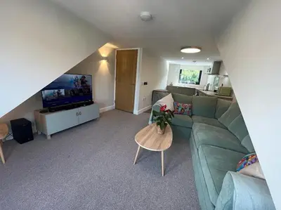 a living room with a green couch and a table at Waverley Apartments - The Wedge in Gourock