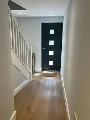 a hallway with a black door and a wooden floor at Waverley Apartments - The Wedge in Gourock