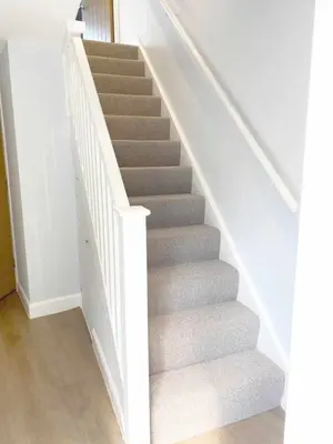a staircase with grey carpet and white railings at Waverley Apartments - The Wedge in Gourock