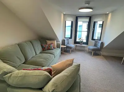 a living room with a green couch and chairs at Waverley Apartments - The Wedge in Gourock