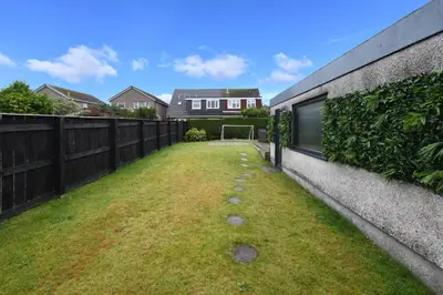 a backyard with a fence and a soccer ball at Links Golf Villa in Troon